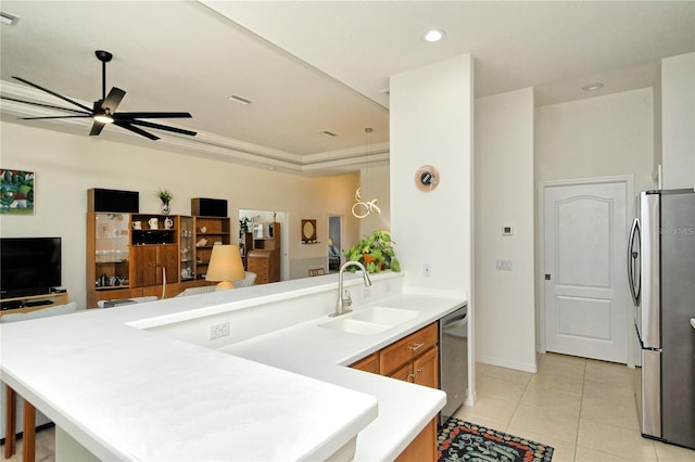 kitchen with a peninsula, ceiling fan, a sink, appliances with stainless steel finishes, and open floor plan