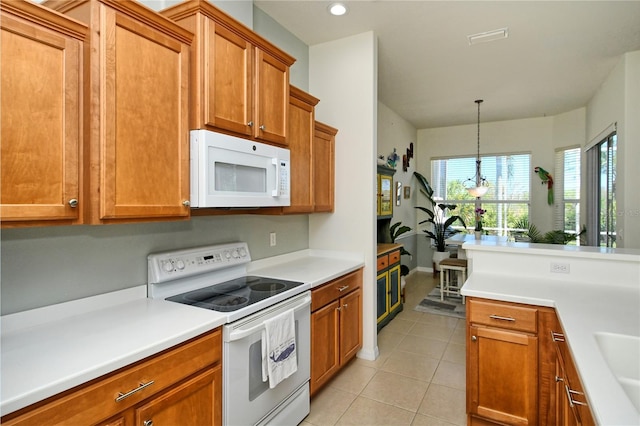 kitchen featuring light tile patterned floors, brown cabinets, white appliances, and light countertops