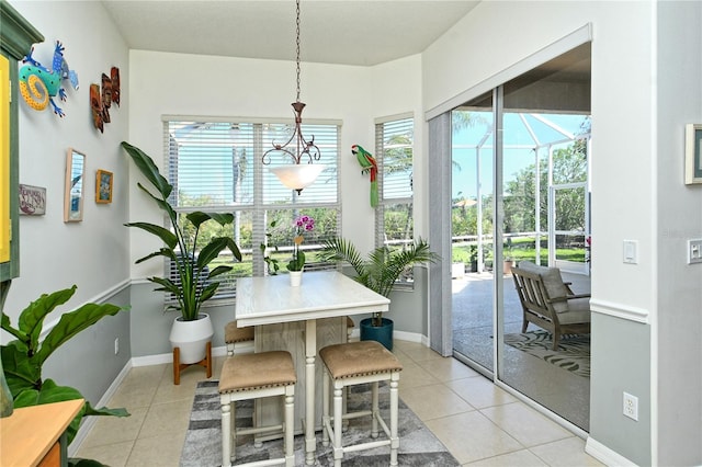 dining area featuring light tile patterned flooring, baseboards, and a sunroom