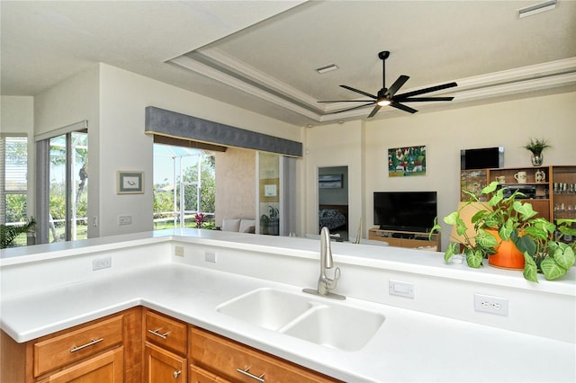 kitchen with a raised ceiling, visible vents, open floor plan, and a sink