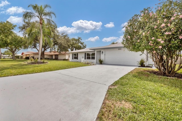 ranch-style home featuring a front yard, a garage, driveway, and stucco siding