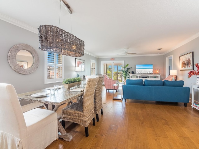 dining area with a ceiling fan, light wood-style floors, and ornamental molding