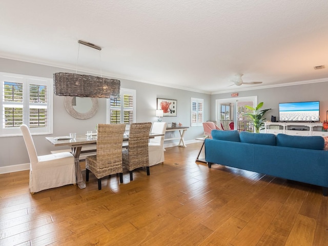 dining room featuring a wealth of natural light, light wood-type flooring, and ornamental molding