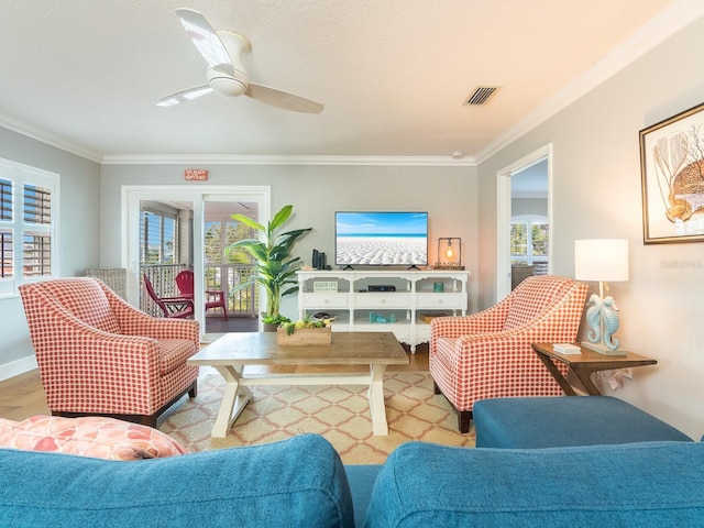 living room with crown molding, plenty of natural light, visible vents, and ceiling fan