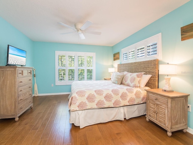 bedroom with a ceiling fan, baseboards, and wood finished floors