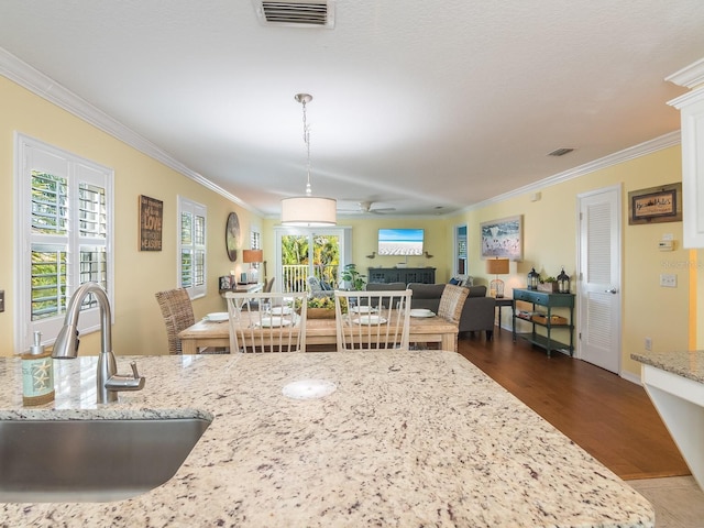 dining space with visible vents, dark wood-style floors, ornamental molding, and a fireplace