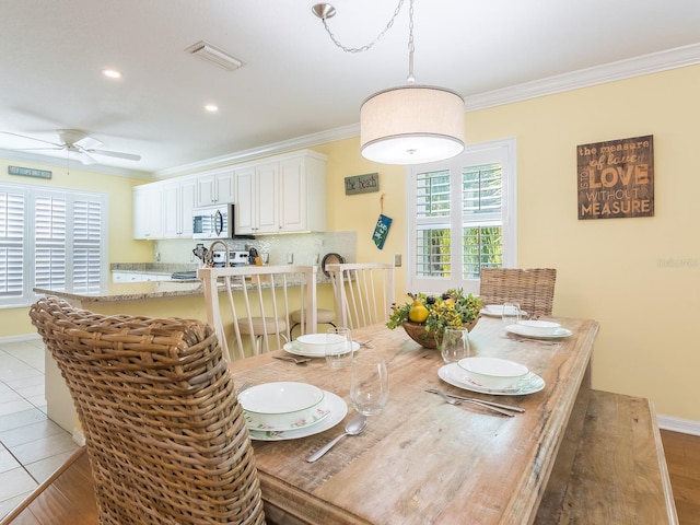 dining area with visible vents, baseboards, ceiling fan, and ornamental molding