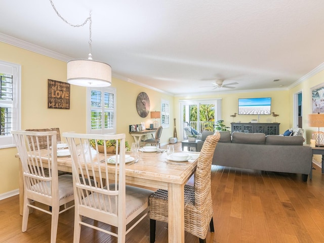 dining room with wood finished floors, a wealth of natural light, and ornamental molding