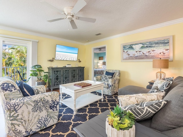 living area with ceiling fan, wood finished floors, visible vents, and ornamental molding