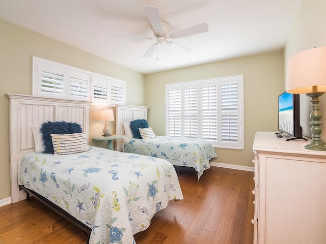 bedroom with hardwood / wood-style flooring, a ceiling fan, and baseboards