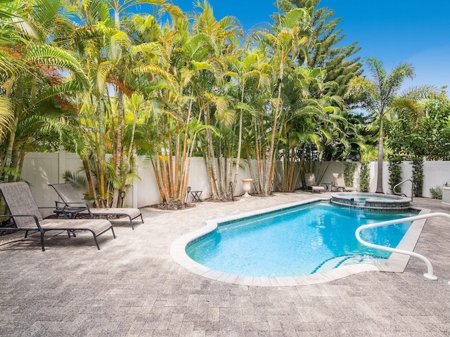 view of pool with a patio area, a pool with connected hot tub, and a fenced backyard