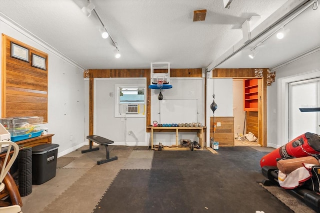 garage featuring wood walls, cooling unit, and baseboards