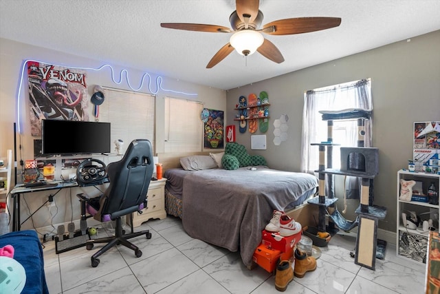 bedroom featuring marble finish floor, a textured ceiling, and a ceiling fan