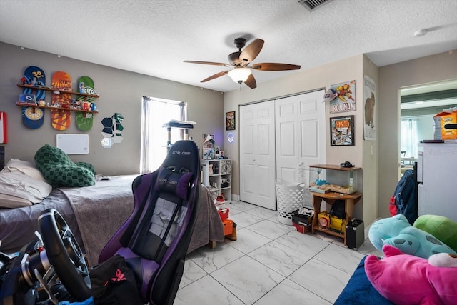 bedroom featuring visible vents, marble finish floor, a textured ceiling, a closet, and ceiling fan