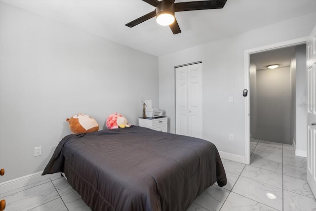 bedroom featuring baseboards, marble finish floor, a closet, and ceiling fan