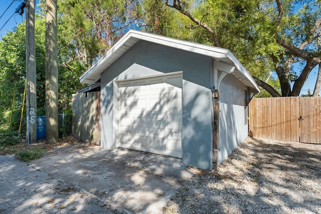 detached garage with driveway and fence