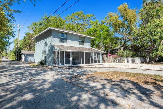 rear view of property with fence and a sunroom