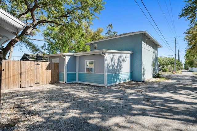 view of home's exterior featuring stucco siding and fence