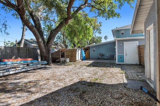 view of yard with central AC unit, a fenced backyard, and a patio area