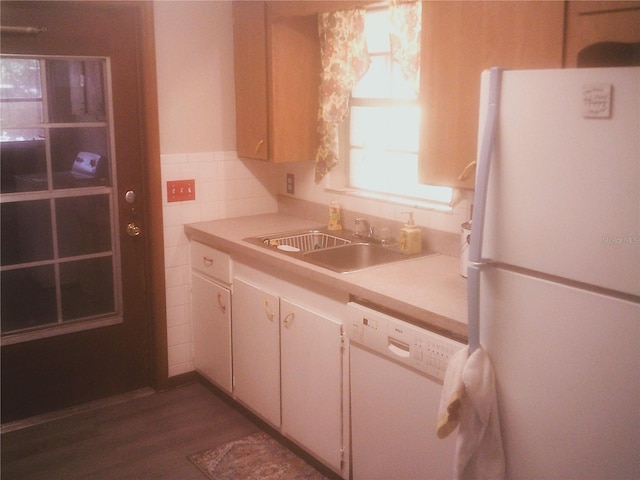 kitchen with white appliances, light countertops, tile walls, and a sink