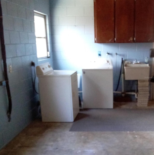 washroom featuring washer and dryer, cabinet space, and a sink