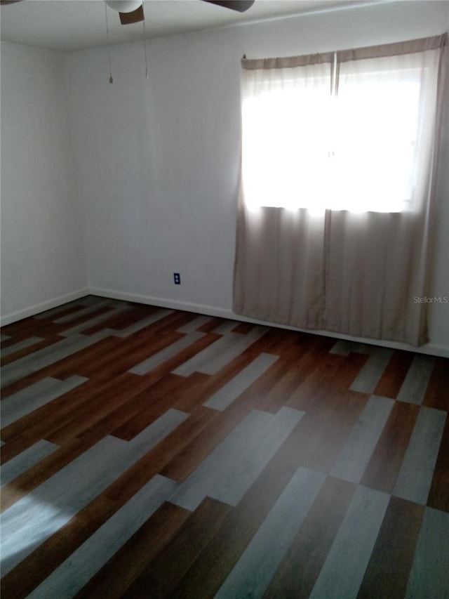 unfurnished room featuring wood finished floors, baseboards, and ceiling fan