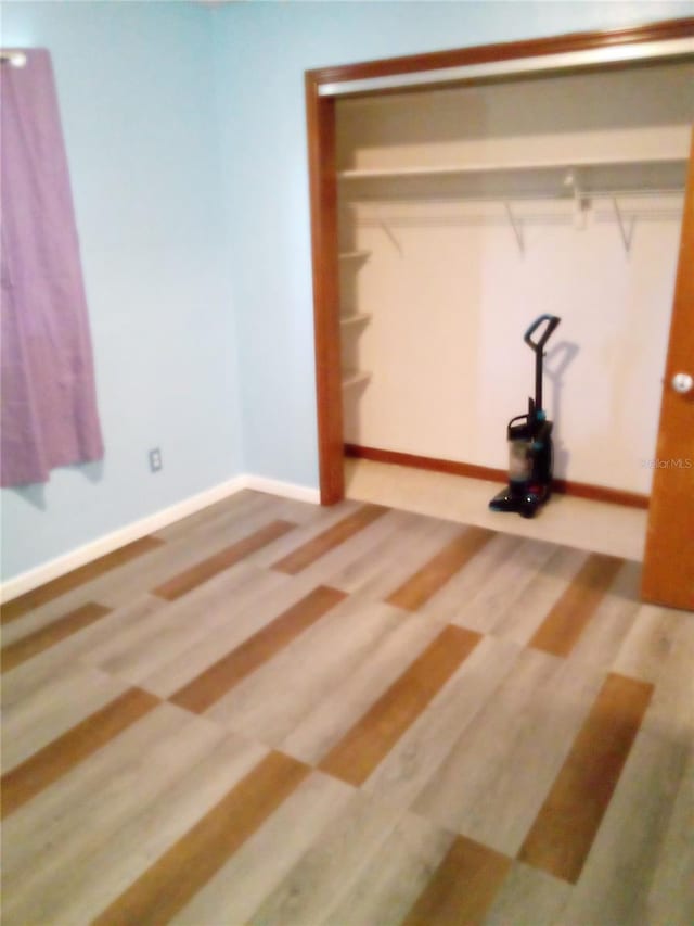 unfurnished bedroom with baseboards and wood finished floors