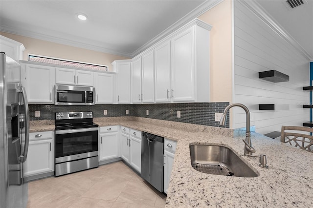 kitchen featuring backsplash, stainless steel appliances, crown molding, and a sink