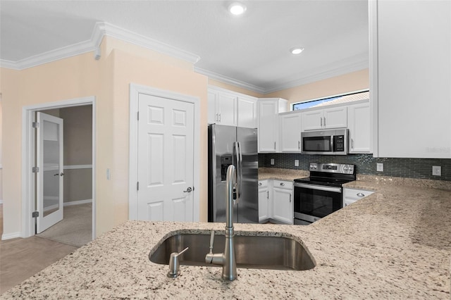 kitchen with tasteful backsplash, crown molding, light stone countertops, stainless steel appliances, and white cabinetry