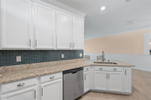 kitchen with a peninsula, a sink, white cabinets, wainscoting, and dishwasher