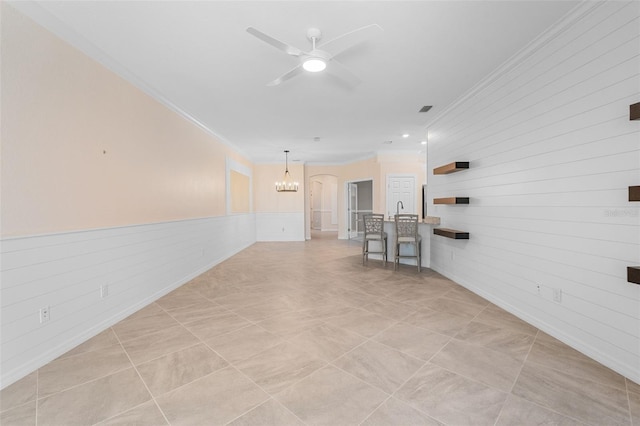 hallway with a wainscoted wall, visible vents, an inviting chandelier, and ornamental molding