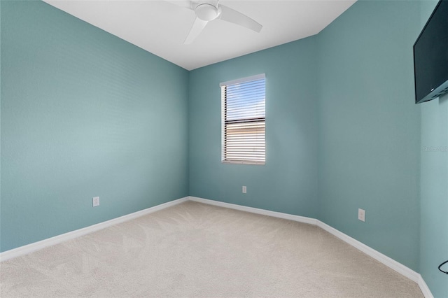 empty room featuring light carpet, baseboards, and ceiling fan