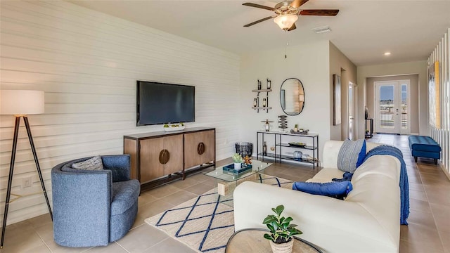 living area with a ceiling fan, light tile patterned flooring, french doors, and visible vents