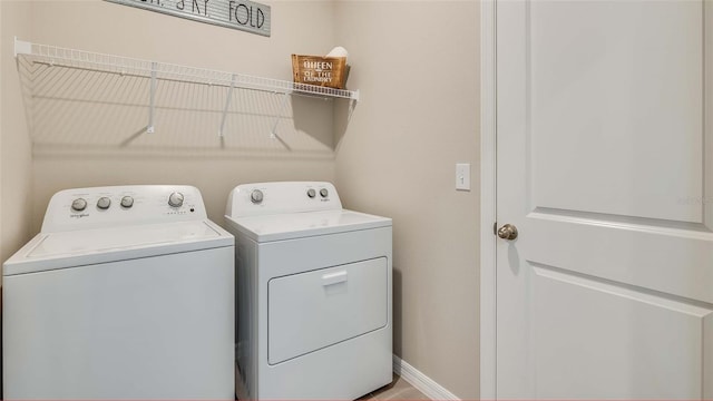 laundry area with baseboards, laundry area, and washer and clothes dryer