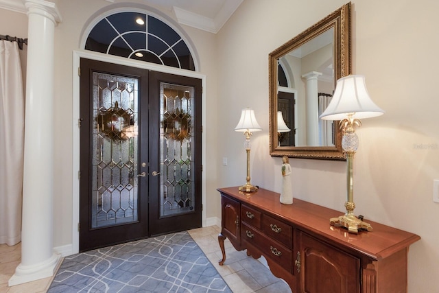 foyer entrance with french doors, light tile patterned flooring, crown molding, baseboards, and ornate columns