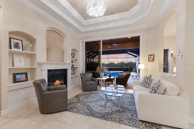 tiled living area with a premium fireplace, ornamental molding, built in shelves, and a sunroom