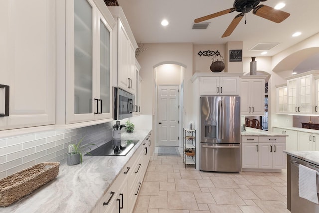 kitchen with visible vents, a ceiling fan, white cabinetry, arched walkways, and appliances with stainless steel finishes