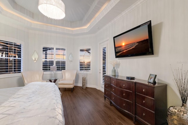 bedroom with a tray ceiling, dark wood finished floors, and crown molding