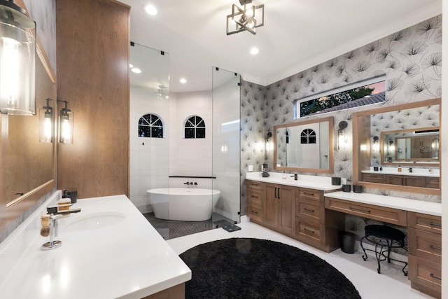 full bath featuring a sink, a freestanding bath, ornamental molding, and wallpapered walls