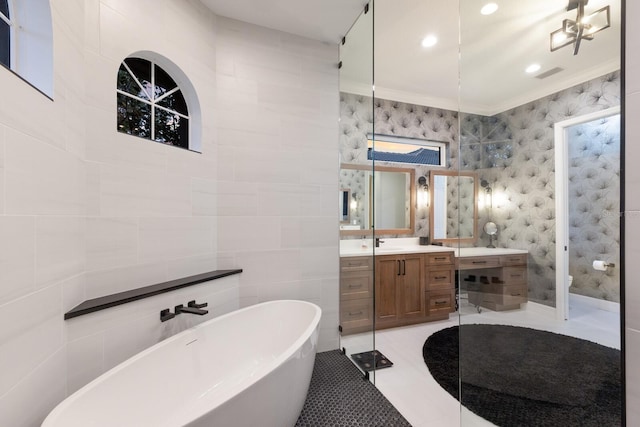 full bath with tile patterned floors, a freestanding tub, visible vents, tile walls, and vanity