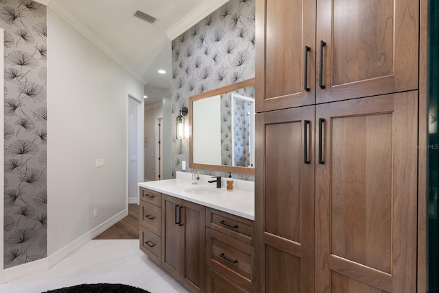 bathroom with wallpapered walls, crown molding, baseboards, and visible vents