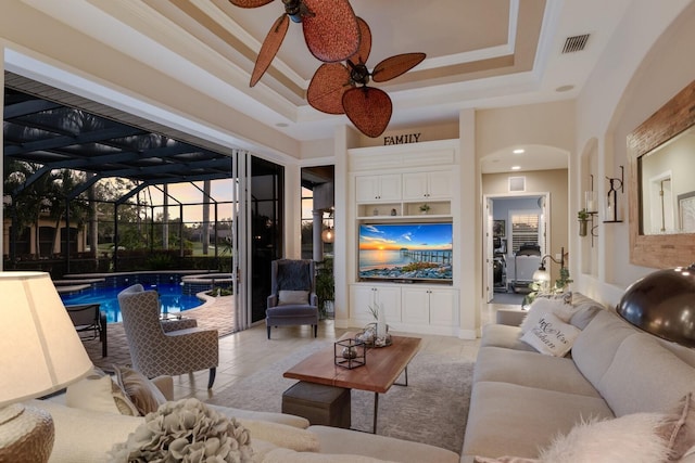 living room with visible vents, a tray ceiling, a sunroom, ceiling fan, and tile patterned floors