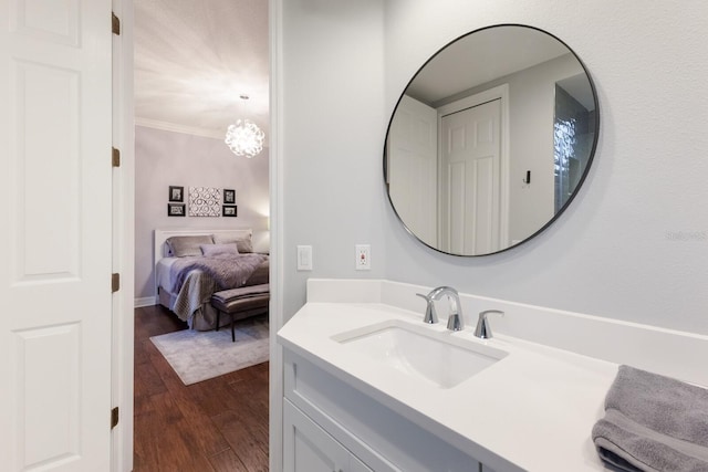 bathroom with vanity, crown molding, and wood finished floors