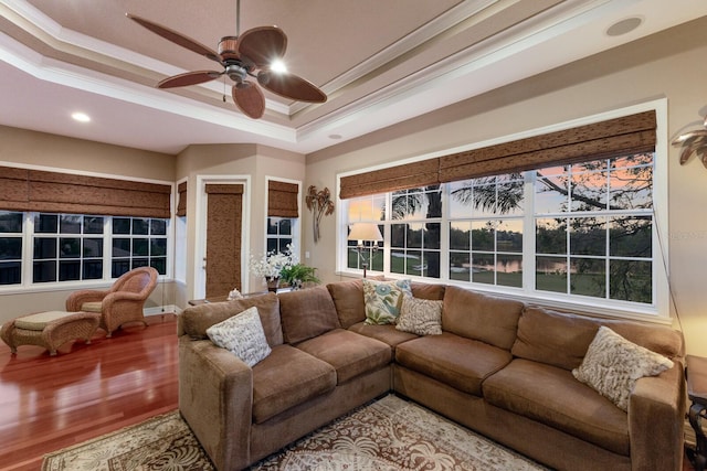 living area featuring crown molding, ceiling fan, a tray ceiling, recessed lighting, and wood finished floors