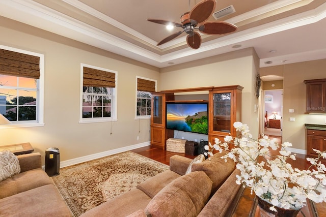 living area featuring visible vents, crown molding, ceiling fan, a tray ceiling, and wood finished floors