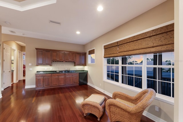 kitchen featuring dark countertops, baseboards, dark wood-type flooring, and arched walkways