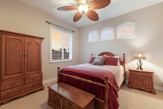 bedroom featuring baseboards, light carpet, and ceiling fan