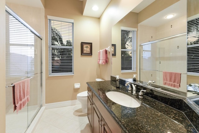 bathroom featuring tile patterned flooring, a shower stall, baseboards, toilet, and vanity