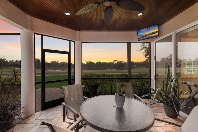 sunroom featuring wood ceiling, a ceiling fan, and a wealth of natural light