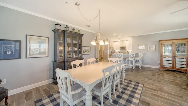 dining room featuring crown molding, baseboards, a chandelier, and wood tiled floor